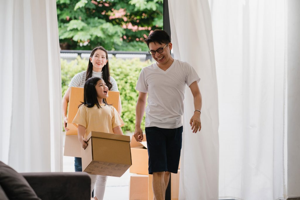 happy asian young family bought new house japanese mom dad child smiling happy hold cardboard boxes move object walking into big modern home new real estate dwelling loan mortgage 1